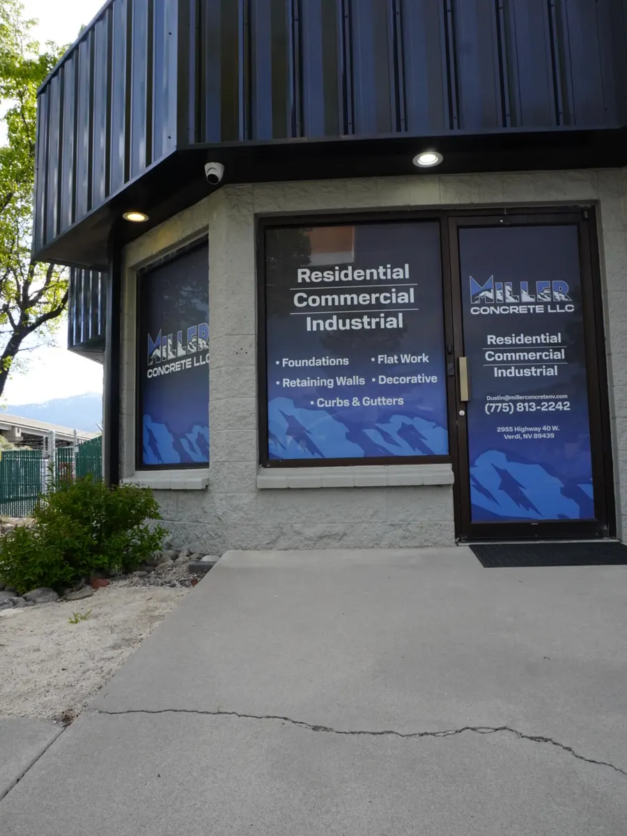 Miller Concrete office windows after, with printed blue graphics listing their concrete services
